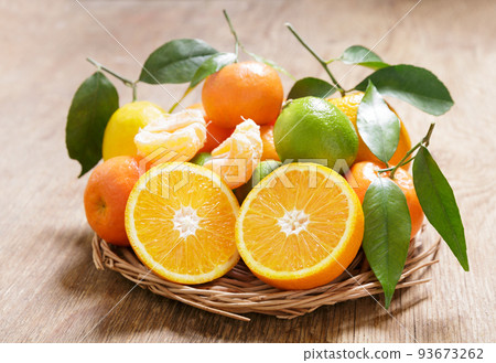 Fresh citrus fruits with leaves on a wooden table 93673262
