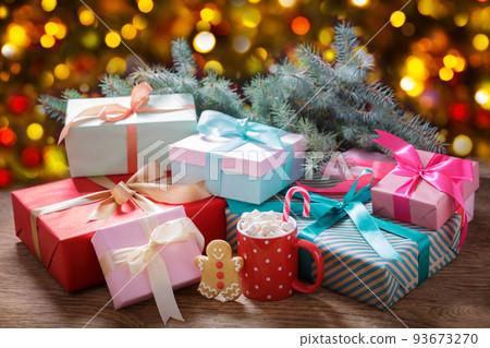 Christmas gift boxes and cup of hot chocolate with marshmallows, gingerbread cookies on a festive background Christmas gift boxes and cup of hot chocolate with marshmallows, gingerbread cookies on a festive background 93673270