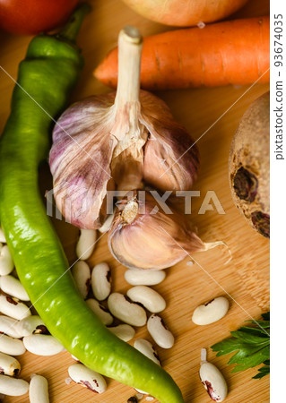 Close-up of fresh vegetables on a wooden cutting board. Close-up of fresh vegetables on a wooden cutting board. 93674035