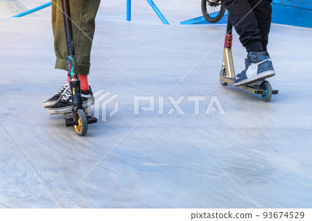 Skater boys having fun practicing at the outdoors skate park on a summer day. Active urban life. Urban subculture. Copy space. Skater boys having fun practicing at the outdoors skate park on a summer day. Active urban life. Urban subculture. Copy space. 93674529