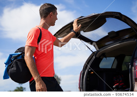 Sportsman getting bag out of trunk outdoors Sportsman getting bag out of trunk outdoors 93674534