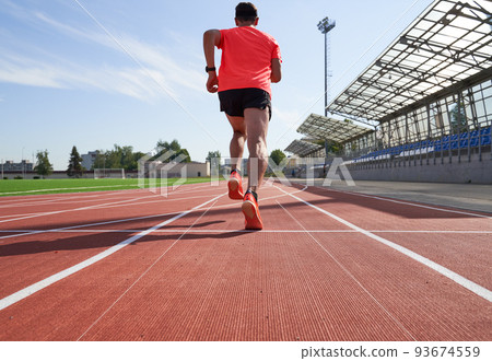 Sport man athlete is running on treadmillat the stadium 93674559