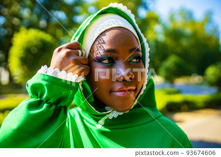 modern authentic multicultural race islamic woman in green cotton hijab with gorgeous make up outdoors in summer park 93674606