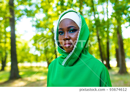 modern authentic multicultural race islamic woman in green cotton hijab with gorgeous make up outdoors in summer park 93674612