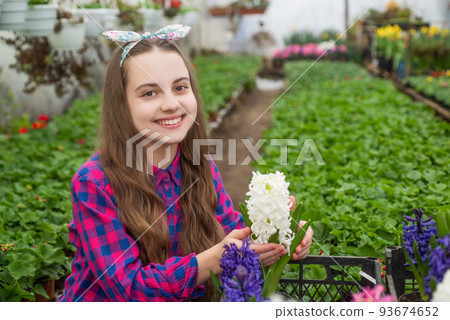 happy teen girl florist care pot plants in greenhouse, home planting 93674652