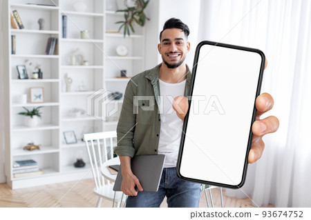 Online Ad. Smiling Arab Man Demonstrating Smartphone With Big Blank Screen 93674752