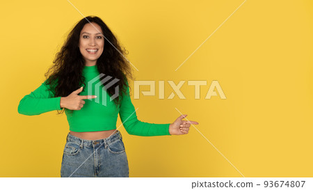 Happy Arabic Lady Pointing Aside At Copy Space, Yellow Background Happy Arabic Lady Pointing Aside At Copy Space, Yellow Background 93674807
