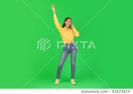 Joyful Woman Listening Music Singing Song Wearing Earbuds, Green Background 93674824