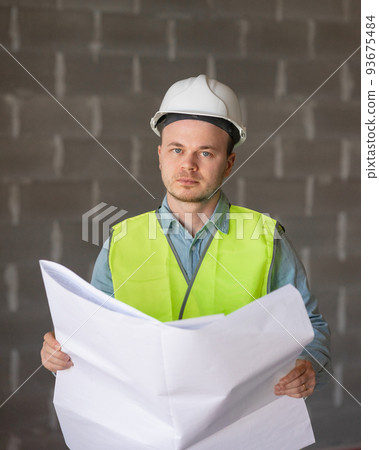 engineer in a white helmet and a protective vest with a project in his hands is thoughtful and professional engineer in a white helmet and a protective vest with a project in his hands is thoughtful and professional 93675484