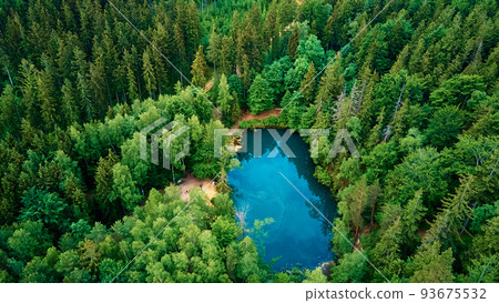 Blue lake in the middle of green forest, aerial view. Wild colorful lake in mountain park in Poland. Beautiful nature landscape Blue lake in the middle of green forest, aerial view. Wild colorful lake in mountain park in Poland. Beautiful nature landscape 93675532