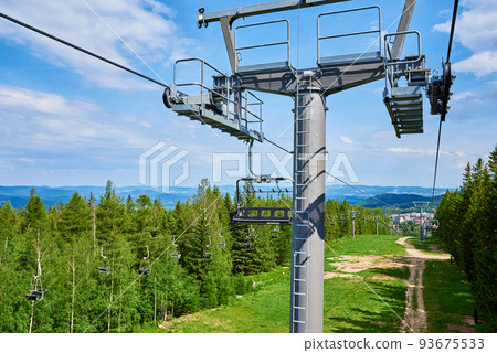 Open cable car line. Metal cable and moving rollers on platform for funicular mechanism, close up. Karpacz resort in Poland with lift road Open cable car line. Metal cable and moving rollers on platform for funicular mechanism, close up. Karpacz resort in Poland with lift road 93675533