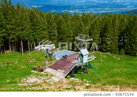 Beautiful mountains, covered with forest and open cable car line. Karpacz resort in Poland with lift road. Family outdoor recreation in mountains Beautiful mountains, covered with forest and open cable car line. Karpacz resort in Poland with lift road. Family outdoor recreation in mountains 93675534