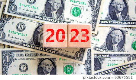 2023 new year symbol. Wooden cubes with number 2023 on a beautiful background from dollar bills, copy space. Business and 2023 new year concept. 93675591