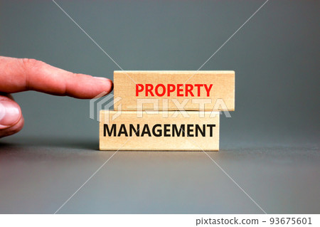 Property management symbol. Concept words Property management on wooden blocks on a beautiful grey table grey background. Businessman hand. Business property management concept. Copy space. 93675601