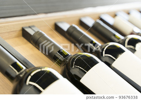 Wine bottles with blank labels on the counter of a liquor store. Wine background. Selected focus Wine bottles with blank labels on the counter of a liquor store. Wine background. Selected focus 93676338
