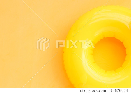Inflatable ring on yellow background. Summer background concept 93676904