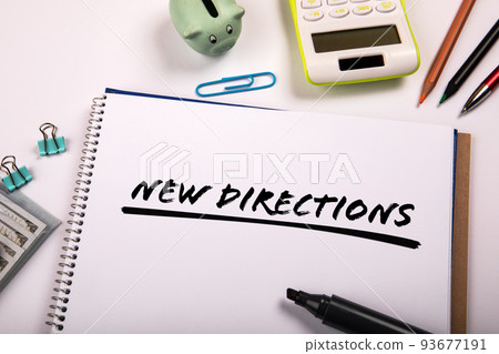 NEW DIRECTIONS. Text on paper. Office supplies on the table NEW DIRECTIONS. Text on paper. Office supplies on the table 93677191