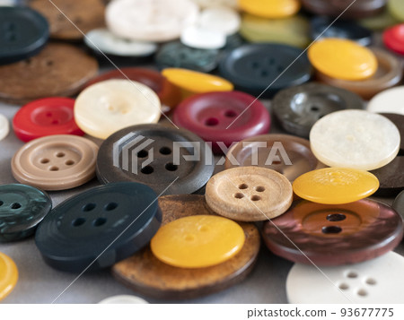 Round sewing buttons of different colours and sizes, close up. Variety of colored flat buttons with two or four holes Round sewing buttons of different colours and sizes, close up. Variety of colored flat buttons with two or four holes 93677775