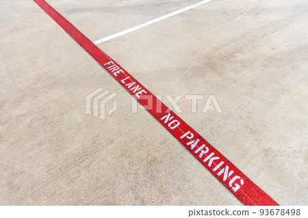 Fire lane no parking marking on the asphalt of a parking lot, tow away zone, red fire lane painted on the road, car parking is prohibited 93678498