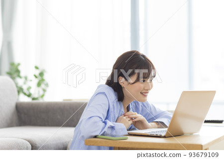 A young lady watching a computer 93679109
