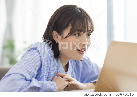 A young lady watching a computer 93679110