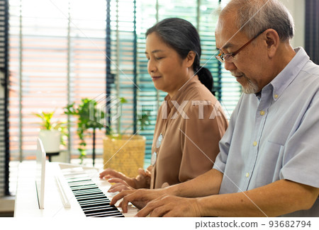 Elderly senior couple play Piano music together. Group of Two Asian smart mature Person retire and get pension fund. Grandparent express feeling happy treatment. Concept grow old together, copy space Elderly senior couple play Piano music together. Group of Two Asian smart mature Person retire and get pension fund. Grandparent express feeling happy treatment. Concept grow old together, copy space 93682794