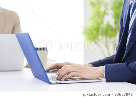 At the hands of a businessman who uses a laptop in the office At the hands of a businessman who uses a laptop in the office 93682948