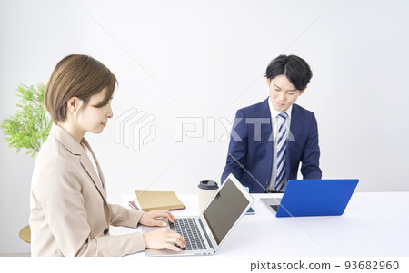 Businesswoman and businessman using laptop in office Businesswoman and businessman using laptop in office 93682960