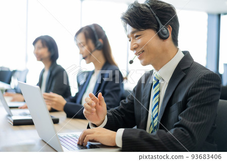 A man in his 50s in a suit doing customer support A man in his 50s in a suit doing customer support 93683406