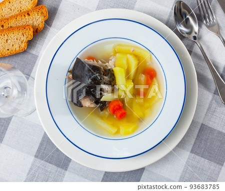 Salmon head soup with potatoes and carrots served with toasts Salmon head soup with potatoes and carrots served with toasts 93683785