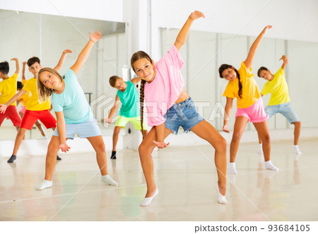 Group of kids training modern dance moves Group of kids training modern dance moves 93684105
