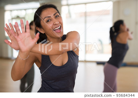 Portrait of young smiling hispanic woman dancing Portrait of young smiling hispanic woman dancing 93684344