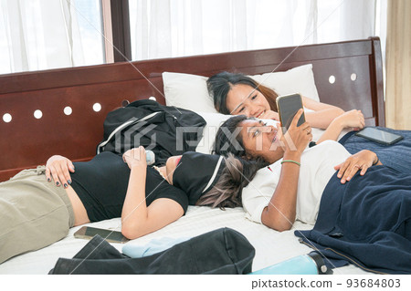 Young women lying on bed, sleep over party concept. 93684803