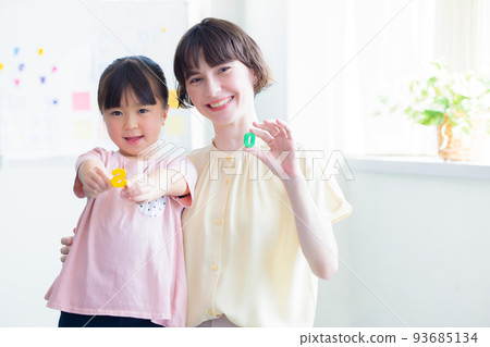 Education A child taking a lesson in an English conversation class and a native teacher Education A child taking a lesson in an English conversation class and a native teacher 93685134