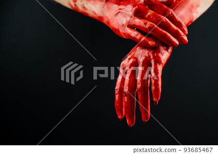 Women's hands in blood on a black background. 93685467