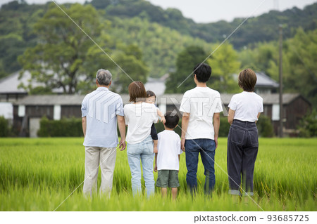 Rear view Group photo of a three-generation family returning to their hometown Taken on a footpath in the countryside 93685725