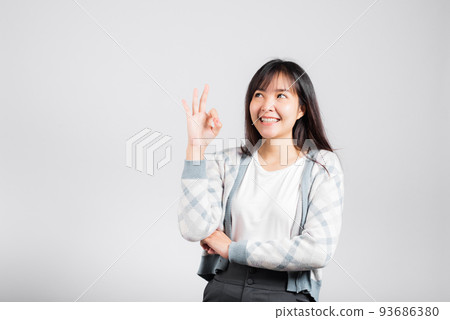 Woman smiling showing made finger OK symbol sign to agree 93686380