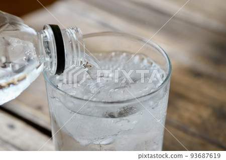 將塑膠瓶中的碳酸水倒入玻璃杯中 93687619