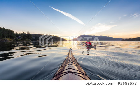 Adventurous Woman on Sea Kayak paddling in the Pacific Ocean. Sunny Summer Sunset Adventurous Woman on Sea Kayak paddling in the Pacific Ocean. Sunny Summer Sunset 93688658