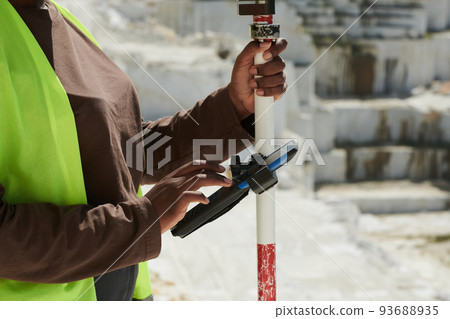 Hands of young black woman in workwear scrolling through settings in smartphone 93688935