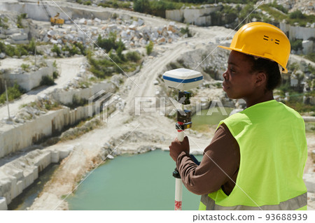Young serious African American female engineer or surveyor with theodolite 93688939
