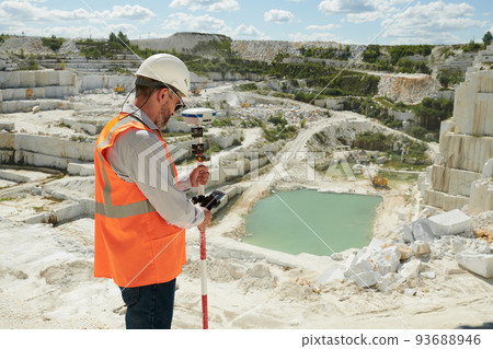 Side view of mature engineer or surveyor adjusting theodolite before work Side view of mature engineer or surveyor adjusting theodolite before work 93688946