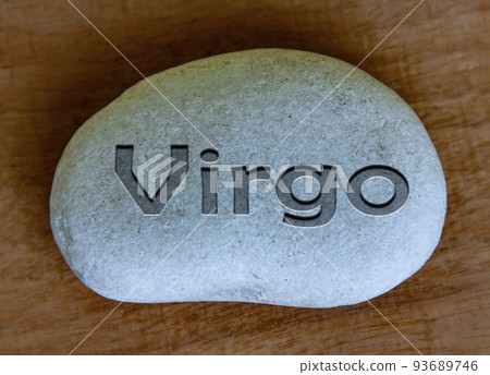 Virgo zodiac sign text engraved on a stock with wooden background. Zodiac sign concept. 93689746