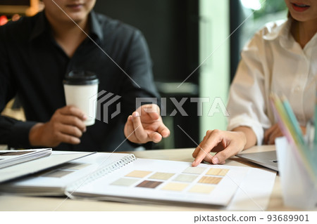Two professional interior designers are working with color swatches and brainstorming for new project at co working space Two professional interior designers are working with color swatches and brainstorming for new project at co working space 93689901