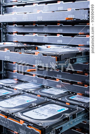 close up of hard disk drives inside hosting center - server rack filled with trays full of data storage drives 93690499