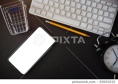 Top view from above of equipment placed and notebook, shopping cart, keyboard, smartphone. Space for modern creative work of designer. Top view from above of equipment placed and notebook, shopping cart, keyboard, smartphone. Space for modern creative work of designer. 93691610