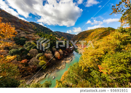 秋天從京都嵐山公園龜山天文台看到的桂川在秋葉和藍天背景中流動的山間 93691931