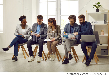 Candidates for position in business office communicate together and prepare for interview. 93692291