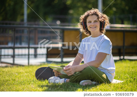 Pleased teen listening to music in nature 93693079
