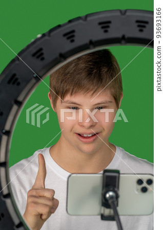 Fair-haired boy fixing camera and looking involved 93693166